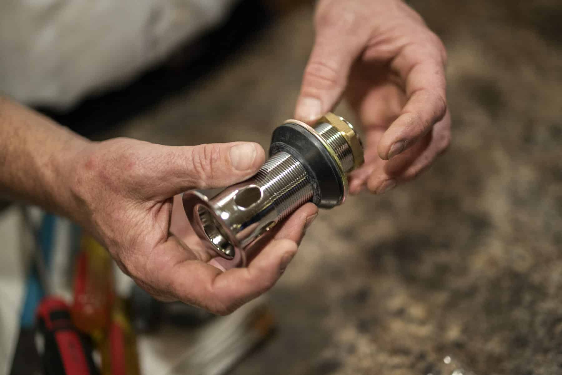 Utah Plumber holds plumbing drain to replace in home