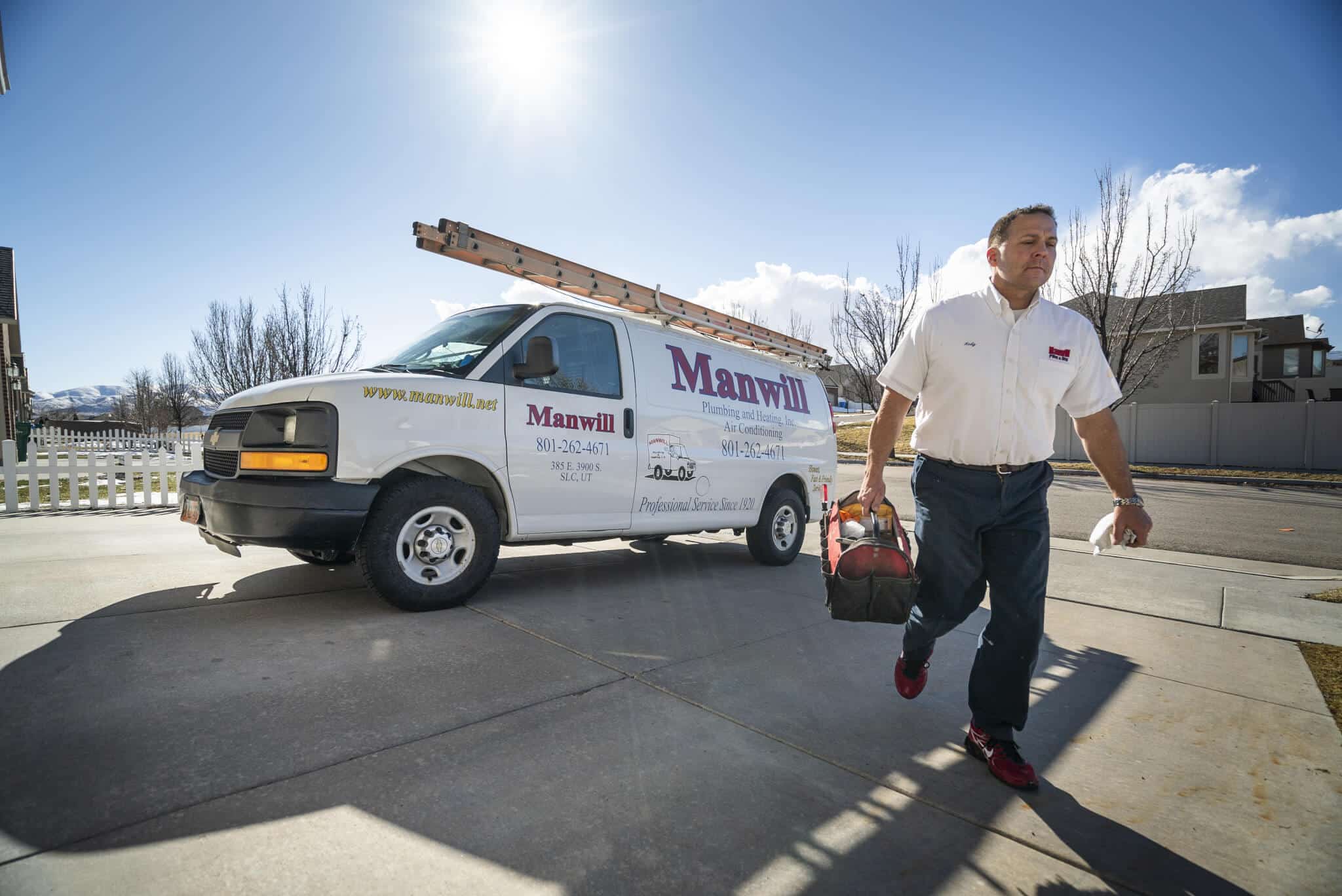Manwill plumber walks up driveway to do plumbing service at Utah Home