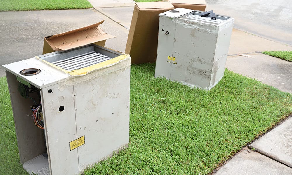 furnaces on grass before technicians replace furnace in SLC