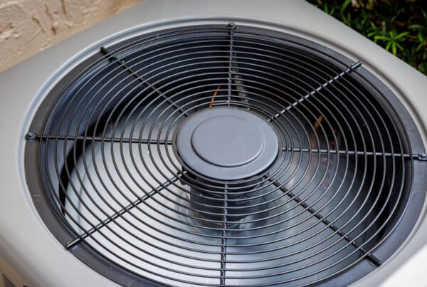 Close-up of the fan and grille on an outdoor air conditioning condenser unit